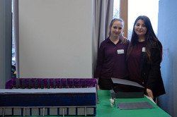 Zwei Studentinnen der TH Mittelhessen stehen neben einem Modell für eine Sanitäranlage mit Trocken-Trenntoiletten.
