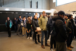 Viele Studierende stehen in einer Schlange und warten darauf, ihr Namensschild zu bekommen.