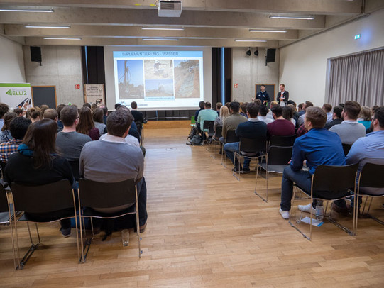 Die IoG Regionalgruppe Ruhrgebiet stellt in einem Vortrag ihre Arbeit vor. Im Plenum sitzen Studierende und Lehrende und hören zu.
